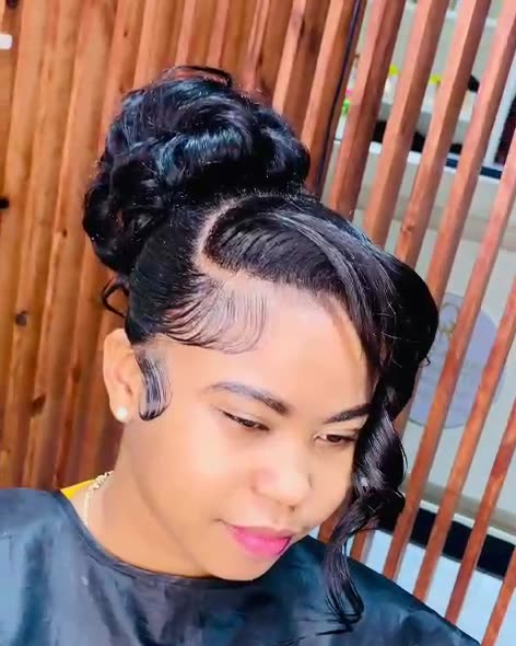 Coiffure terminée avec chignon, mèche bouclée et baby hairs sculptés, réalisée à l’académie.